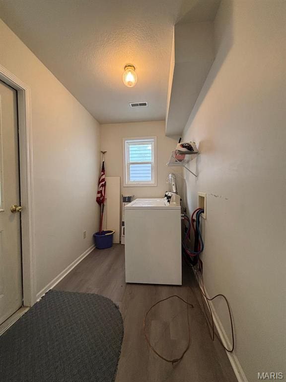 laundry room with wood finished floors, washer / clothes dryer, baseboards, and a textured ceiling