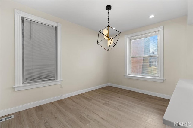 unfurnished dining area featuring baseboards, light wood-style flooring, and recessed lighting