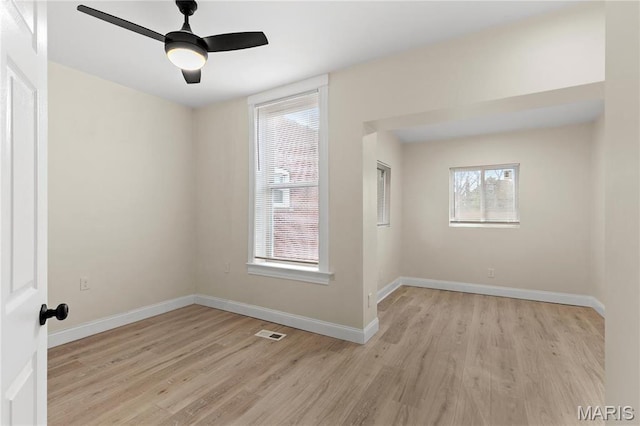 spare room featuring light wood-style flooring, baseboards, and a ceiling fan