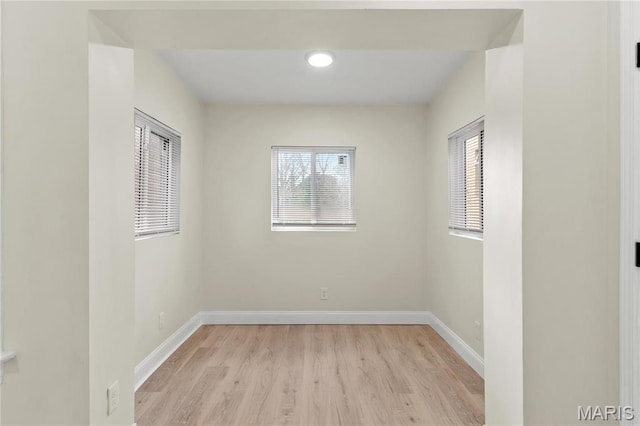 empty room featuring light wood finished floors and baseboards