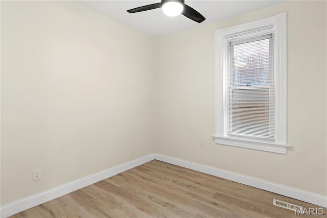 spare room with baseboards, ceiling fan, and light wood-style floors