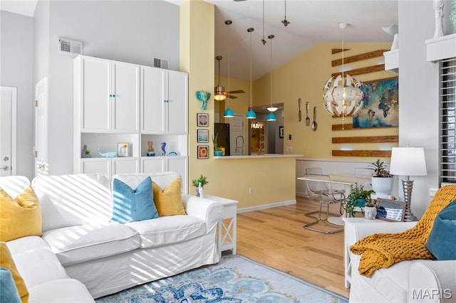 living area with ceiling fan, light wood-style floors, and high vaulted ceiling