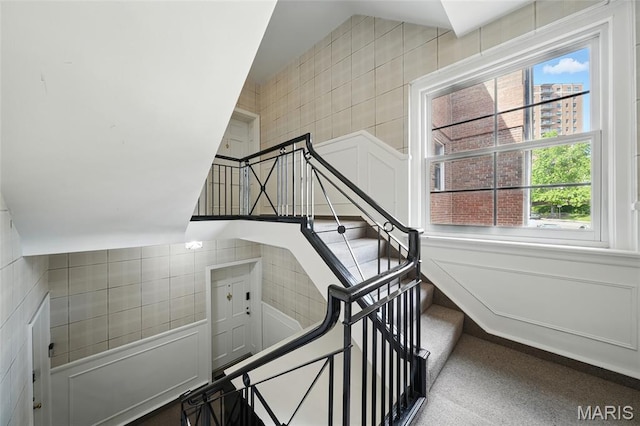 923 S Hanley Rd Unit A, Saint Louis, MO 63105 - staircase with tile walls and a decorative wall