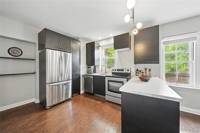 923 S Hanley Rd Unit A, Saint Louis, MO 63105 - kitchen featuring appliances with stainless steel finishes, light countertops, a peninsula, and a sink