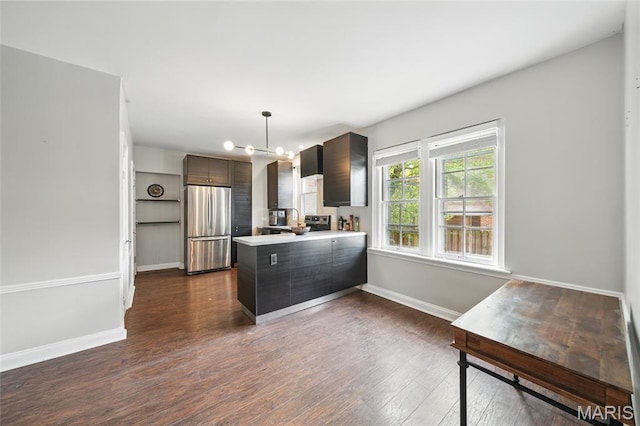 923 S Hanley Rd Unit A, Saint Louis, MO 63105 - kitchen with freestanding refrigerator, a peninsula, baseboards, light countertops, and dark wood-style flooring