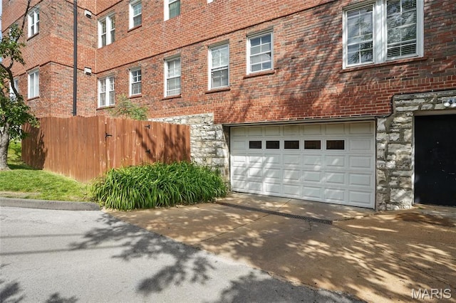 923 S Hanley Rd Unit A, Saint Louis, MO 63105 - view of property exterior with stone siding, a garage, driveway, and brick siding