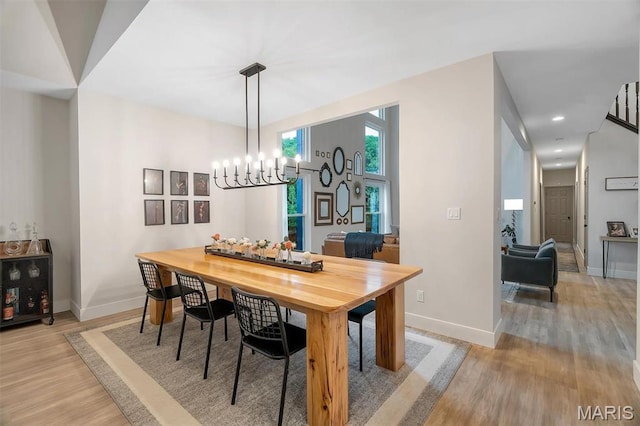 dining room with wood finished floors, baseboards, and a chandelier