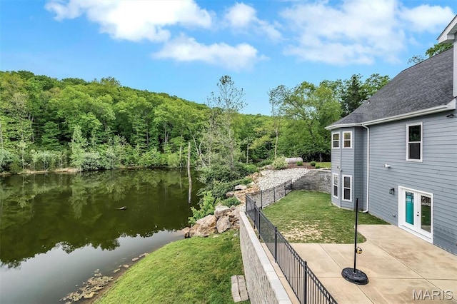 water view with fence and a heavily wooded area