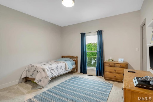 bedroom featuring light carpet and baseboards