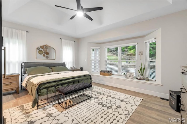 bedroom featuring light wood-style flooring, baseboards, and a ceiling fan