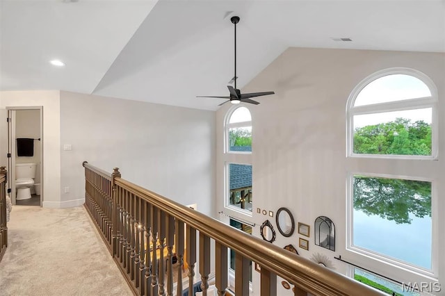corridor with high vaulted ceiling, an upstairs landing, light colored carpet, baseboards, and recessed lighting