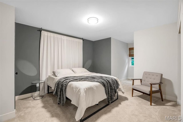 bedroom featuring light colored carpet and baseboards
