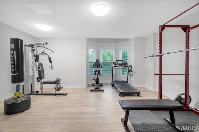 exercise area with wood finished floors and baseboards