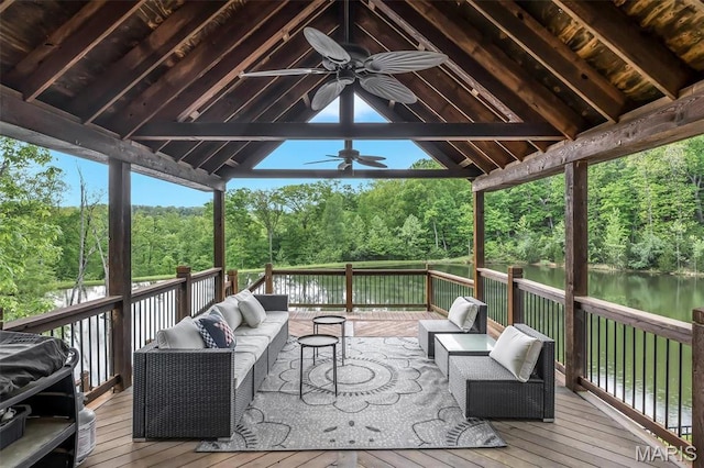 deck featuring a ceiling fan, outdoor lounge area, and a water view