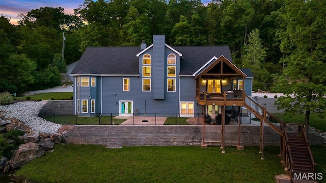 rear view of house featuring stairway, a chimney, french doors, and a wooden deck