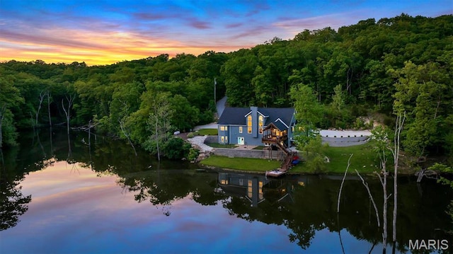 view of property location with a forest and a large body of water