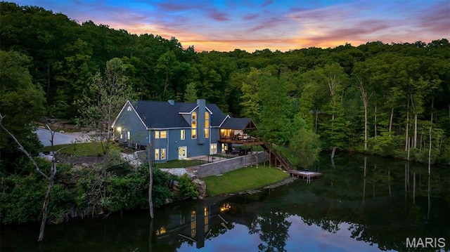 aerial overview of property's location featuring a forest and a large body of water