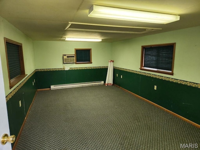 basement featuring baseboard heating, carpet flooring, and a wall unit AC