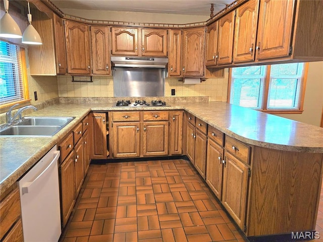 kitchen with a sink, dishwasher, under cabinet range hood, a peninsula, and brown cabinetry
