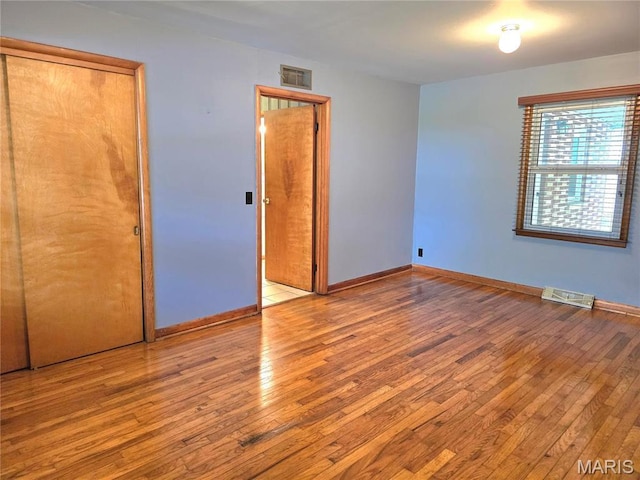 unfurnished bedroom with hardwood / wood-style floors and baseboards