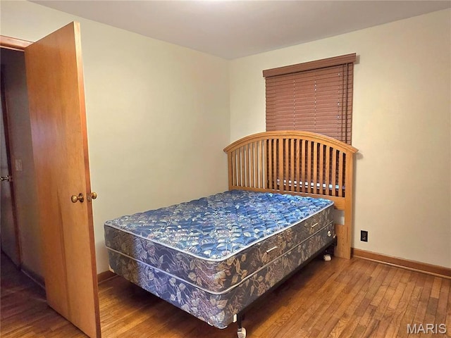 bedroom featuring wood finished floors and baseboards