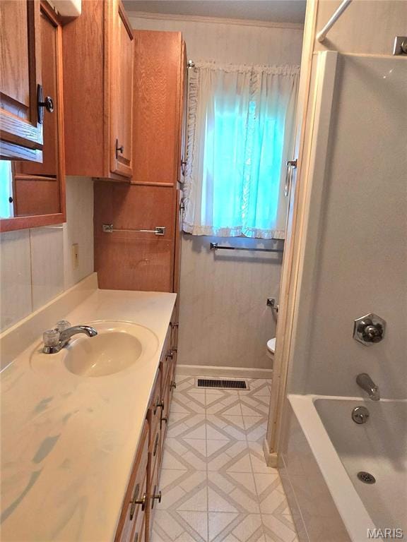 full bath with toilet, vanity, bathtub / shower combination, and baseboards