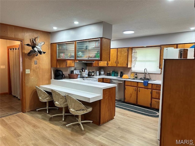 634 N 425th Rd, Bertrand, MO 63823 - kitchen featuring stainless steel dishwasher, brown cabinetry, a sink, a peninsula, and a textured ceiling