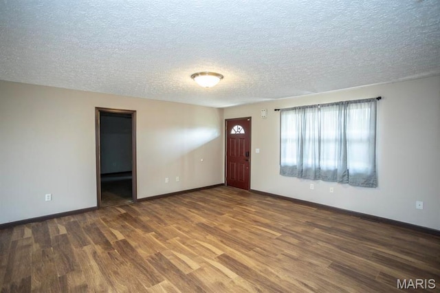 15625 Talon Ln, Saint Robert, MO 65584 - unfurnished living room featuring wood finished floors, a textured ceiling, and baseboards