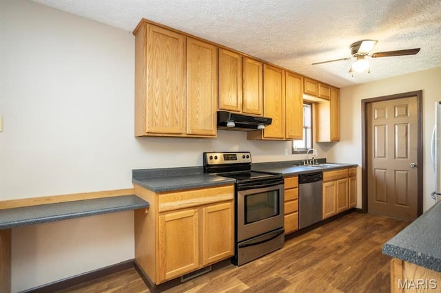 15625 Talon Ln, Saint Robert, MO 65584 - kitchen with stainless steel appliances, under cabinet range hood, a sink, dark countertops, and dark wood-type flooring