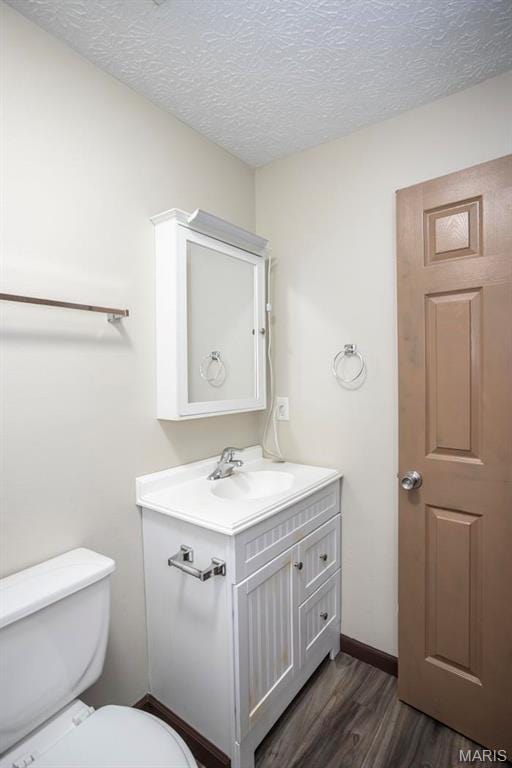 15625 Talon Ln, Saint Robert, MO 65584 - bathroom featuring wood finished floors, toilet, a textured ceiling, vanity, and baseboards