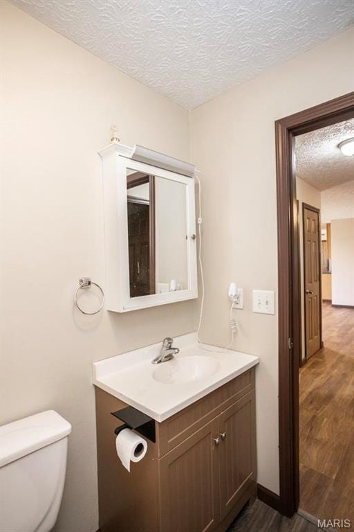 15625 Talon Ln, Saint Robert, MO 65584 - half bath with wood finished floors, a textured ceiling, vanity, and toilet