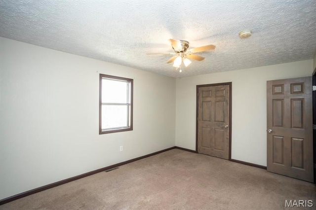 15625 Talon Ln, Saint Robert, MO 65584 - unfurnished bedroom featuring light colored carpet, baseboards, a textured ceiling, and ceiling fan