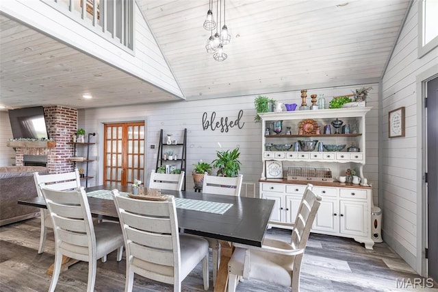 176 Carter 205, Van Buren, MO 63965 - dining space featuring wood walls, wood finished floors, vaulted ceiling, wooden ceiling, and a brick fireplace