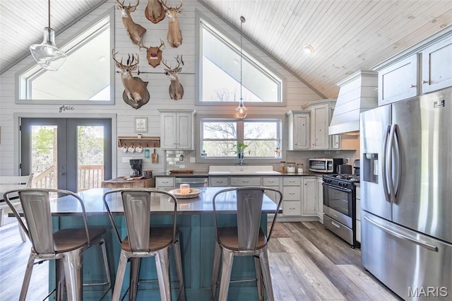 176 Carter 205, Van Buren, MO 63965 - kitchen featuring stainless steel appliances, wood ceiling, wood finished floors, a breakfast bar area, and french doors