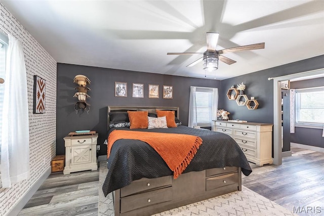 176 Carter 205, Van Buren, MO 63965 - bedroom with an accent wall, light wood-style floors, multiple windows, baseboards, and brick wall