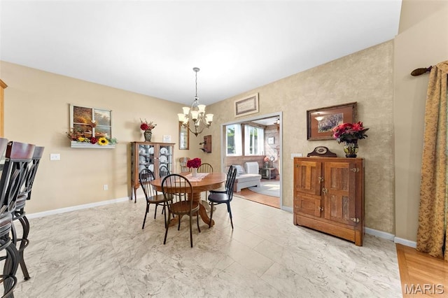 235 River Bluff Ct, Troy, MO 63379 - dining room featuring a chandelier, baseboards, and light marble finish flooring
