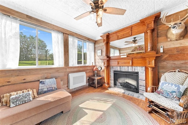 235 River Bluff Ct, Troy, MO 63379 - living area with a ceiling fan, wood finished floors, wood walls, a fireplace, and heating unit