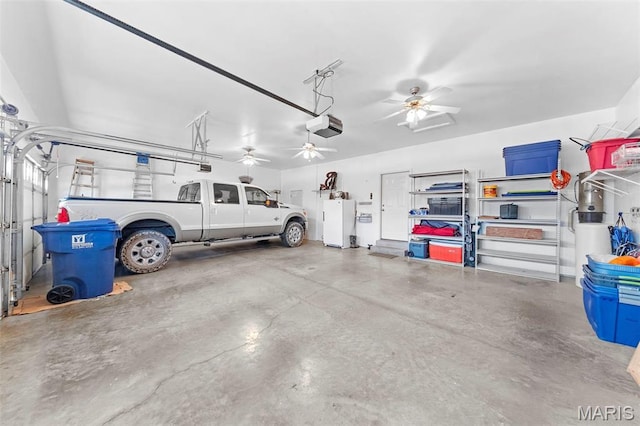 235 River Bluff Ct, Troy, MO 63379 - garage with a garage door opener, freestanding refrigerator, and a ceiling fan