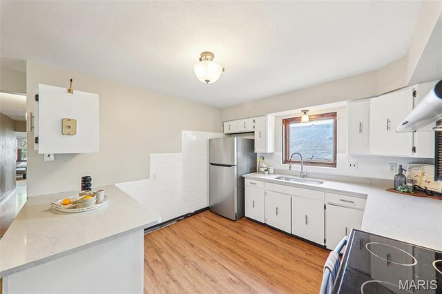 4116 Parker Ave, Saint Louis, MO 63116 - kitchen featuring freestanding refrigerator, electric range, a sink, light countertops, and white cabinets