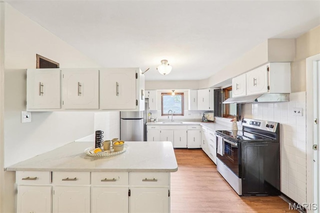 4116 Parker Ave, Saint Louis, MO 63116 - kitchen featuring range with electric cooktop, a sink, freestanding refrigerator, under cabinet range hood, and white cabinetry