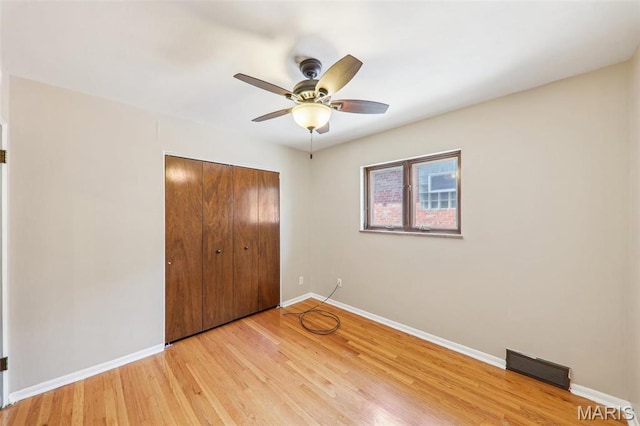 4116 Parker Ave, Saint Louis, MO 63116 - unfurnished bedroom featuring a closet, baseboards, light wood finished floors, and a ceiling fan