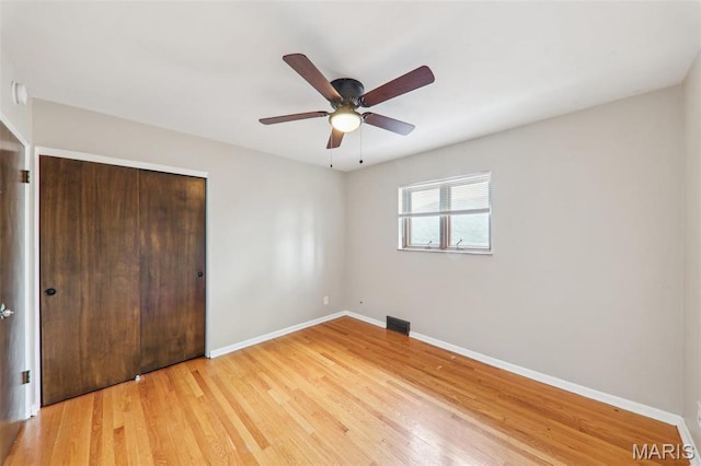 4116 Parker Ave, Saint Louis, MO 63116 - unfurnished bedroom with baseboards, light wood-style floors, a closet, and a ceiling fan