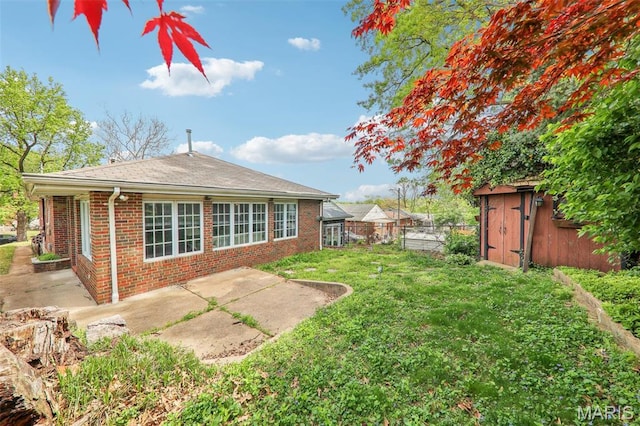 4116 Parker Ave, Saint Louis, MO 63116 - rear view of property with a patio, brick siding, a shed, and an outbuilding