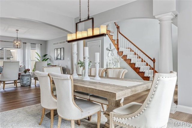2 Pearview Ct, Saint Peters, MO 63376 - dining area featuring arched walkways, wood finished floors, a chandelier, baseboards, and stairs