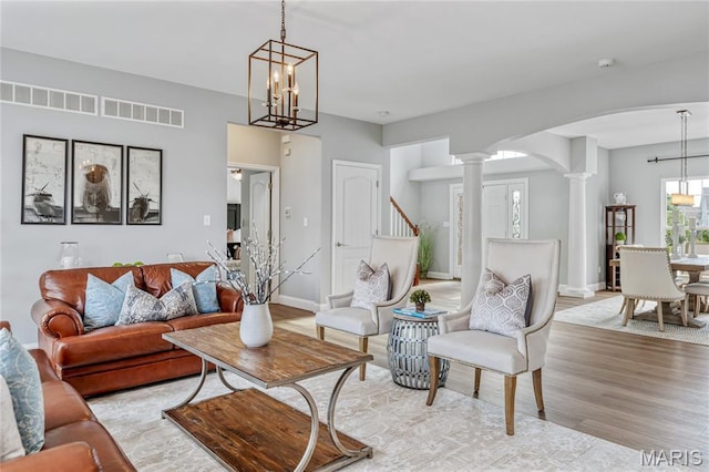 2 Pearview Ct, Saint Peters, MO 63376 - living room with a chandelier, ornate columns, arched walkways, wood finished floors, and baseboards