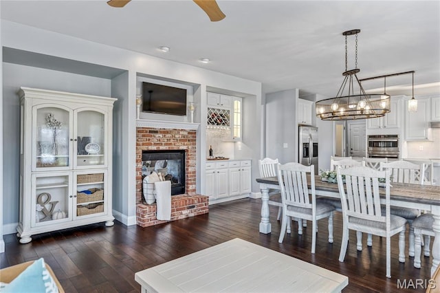 2 Pearview Ct, Saint Peters, MO 63376 - dining area featuring dark wood finished floors, a brick fireplace, baseboards, a chandelier, and a ceiling fan