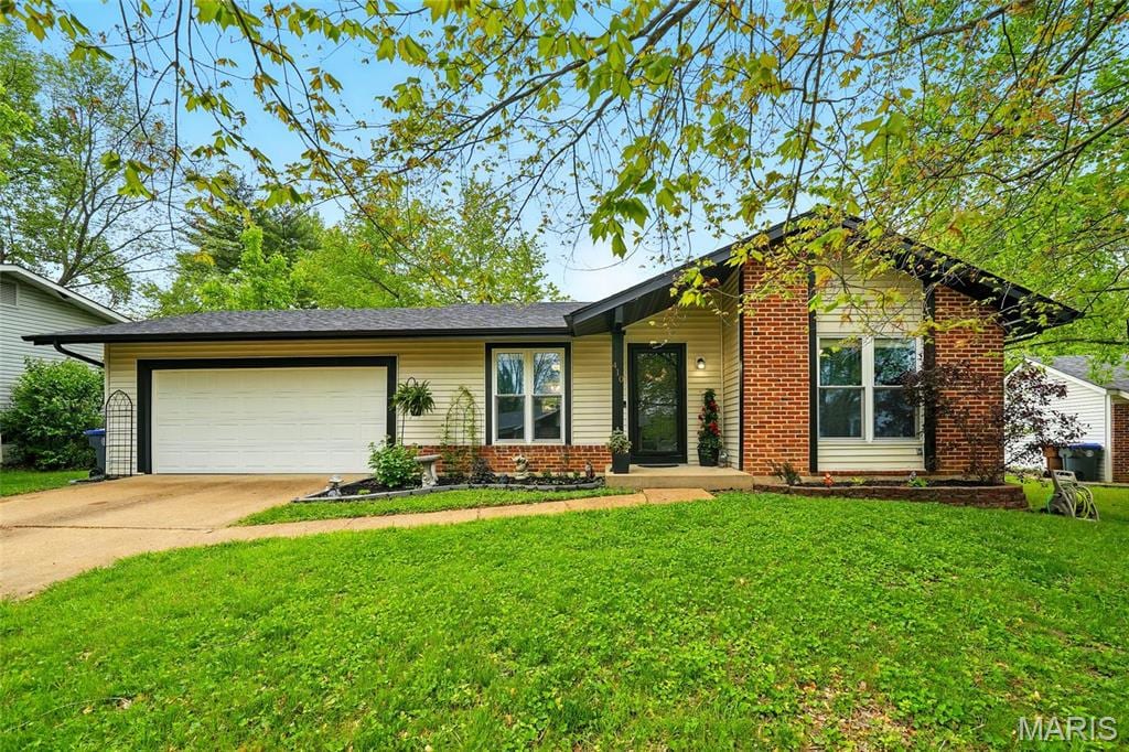 410 Lemonwood Dr, Saint Peters, MO 63376 - view of front of home with an attached garage, concrete driveway, a front yard, and brick siding