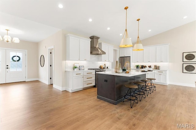 2217 Valleyview Dr, Barnhart, MO 63012 - kitchen with stainless steel appliances, wall chimney range hood, a chandelier, backsplash, and a kitchen breakfast bar