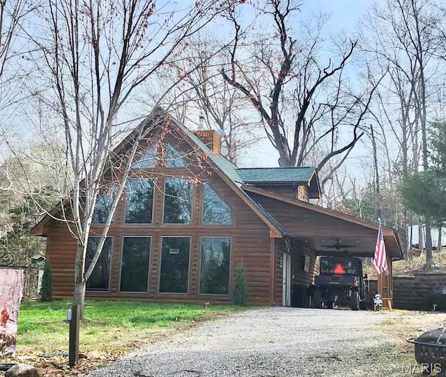 view of front facade with gravel driveway and a carport