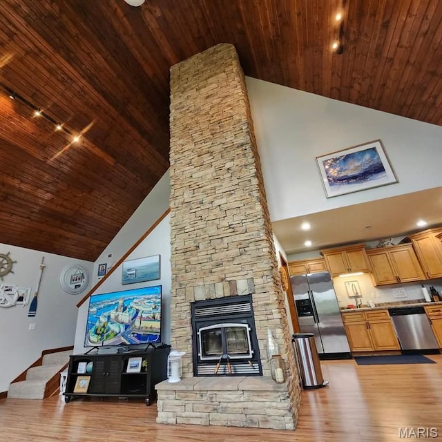 living area with high vaulted ceiling, wooden ceiling, light wood-style floors, track lighting, and baseboards
